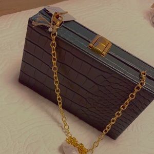 Green clutch with gold traps .